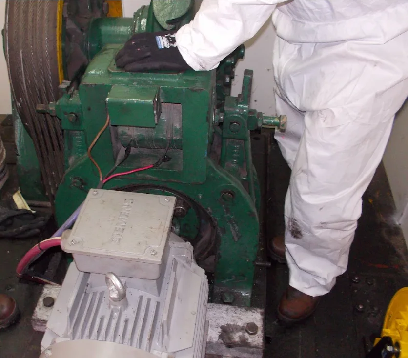 Técnico trabajando sobre el accionamiento de un montacargas industrial